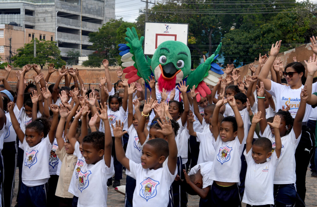 Colí, la mascota de los XXV Juegos Centroamericanos y del Caribe, Santo Domingo 2026, en una de las escuelas del Distrito Nacional. (Crédito: Prensa Santo Domingo 2026)