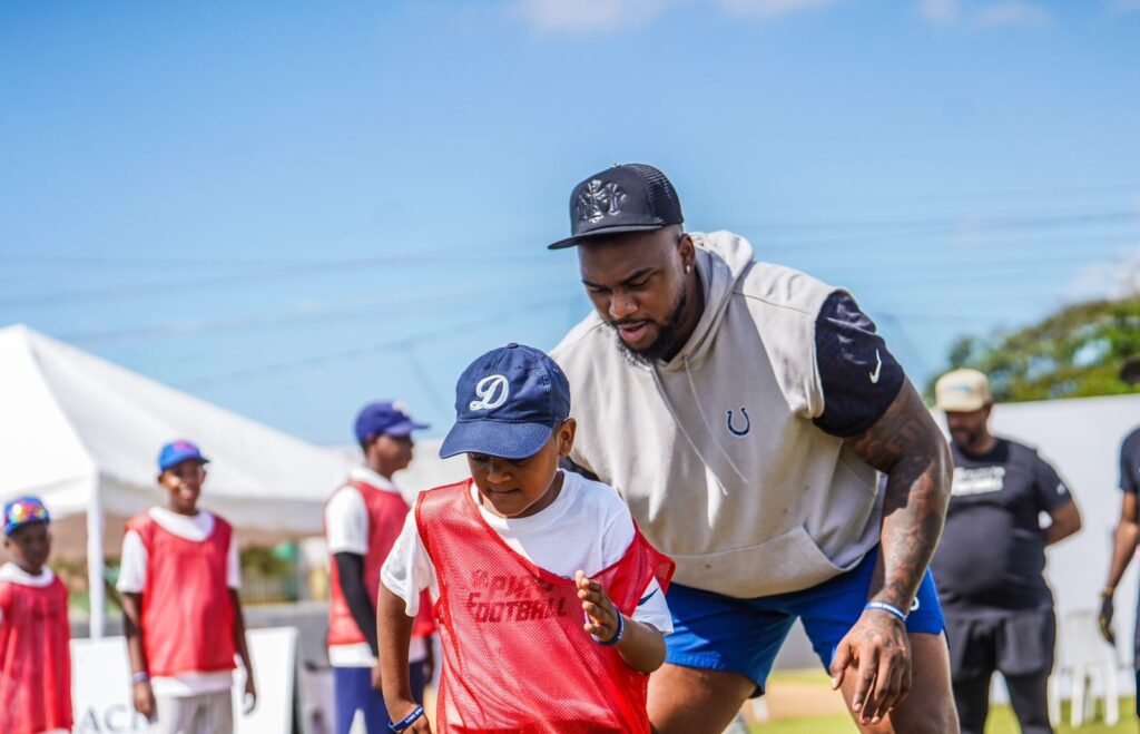 Byron Matos mientras conducía la clínica de Flag Football a uno de los presentes. (Crédito: Prensa INEFI)