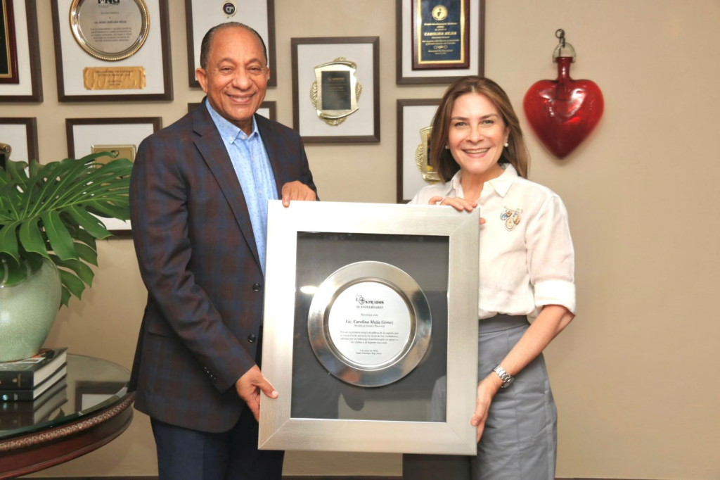 La alcaldesa del Distrito Nacional, Carolina Mejía, recibiendo el reconocimiento de Jorge Ramírez, presidente del Club Los Prados. (Crédito: Prensa Club Los Prados)