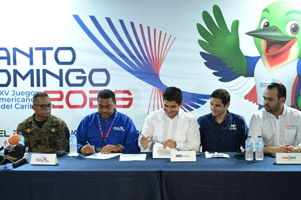 Momento de la firma del convenio entre José Monegro, presidente del Comité Organizador de los Juegos Santo Domingo 2026, y Jhael Isa, vicepresidente ejecutivo de la Empresa Metropolitana de Transporte (EMT). (Crédito: Prensa SDQ2026)
